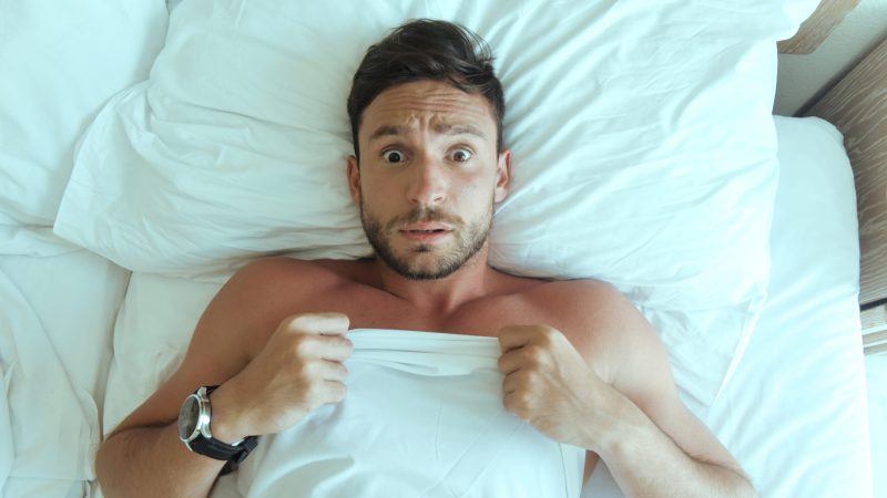 :,Handsome,Man,Laying,Naked,In,Bedroom,Is,Surprised,Over